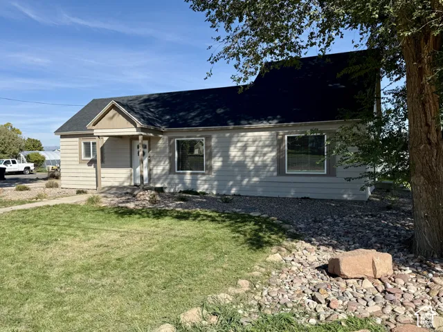 Siding exterior with a covered entry, dark shingle roof, and multiple windows