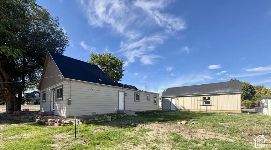 Exterior siding with multiple windows and a dark shingle roof