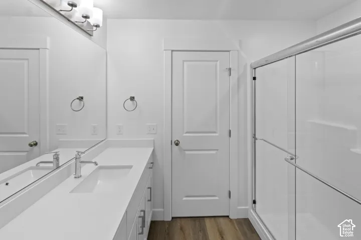 Double vanity with integrated sinks and chrome fixtures, framed by a large mirror and a three-light vanity bar