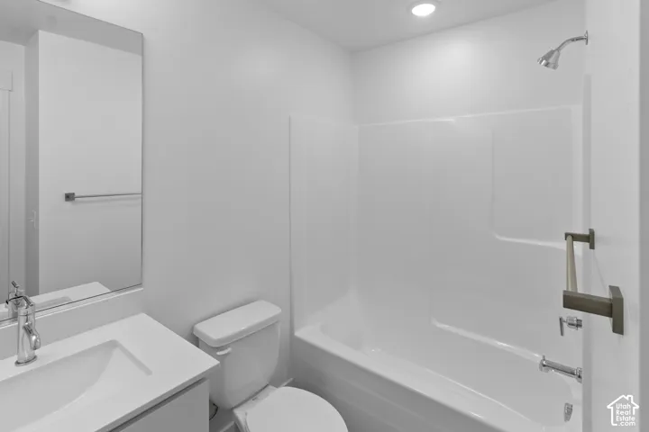 Bathroom featuring a white vanity with an integrated sink, polished chrome faucet, rectangular mirror, and a white tub/shower combination with a shower head