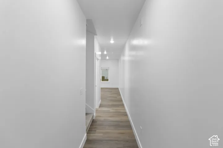 Wood-finish flooring, recessed lighting, white walls, and white trim throughout
