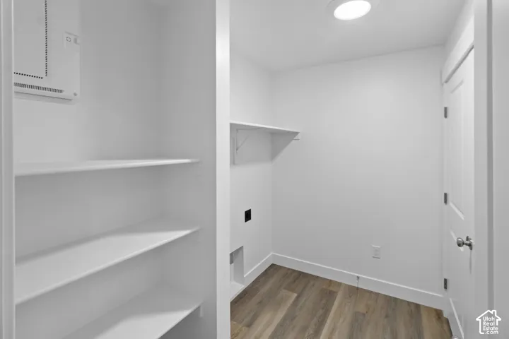 Built-in shelving, recessed ceiling lighting, wood-finish flooring, and a white paneled door