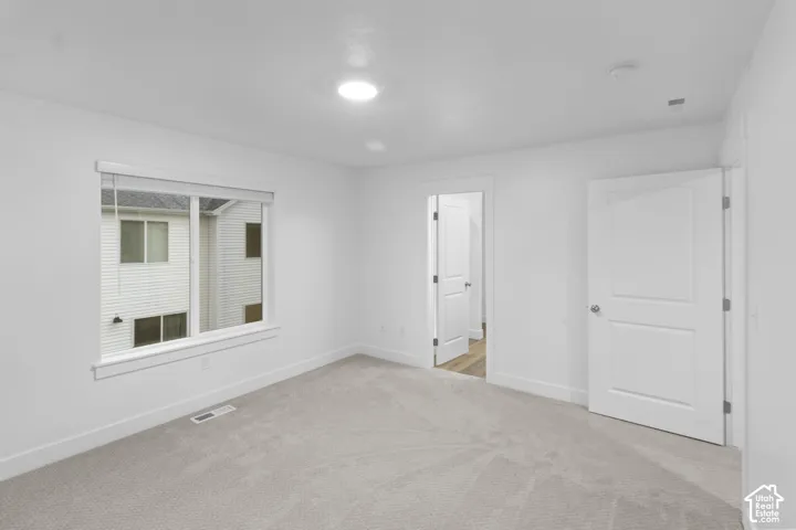 Carpeted flooring, white interior walls, recessed ceiling light, and white trim