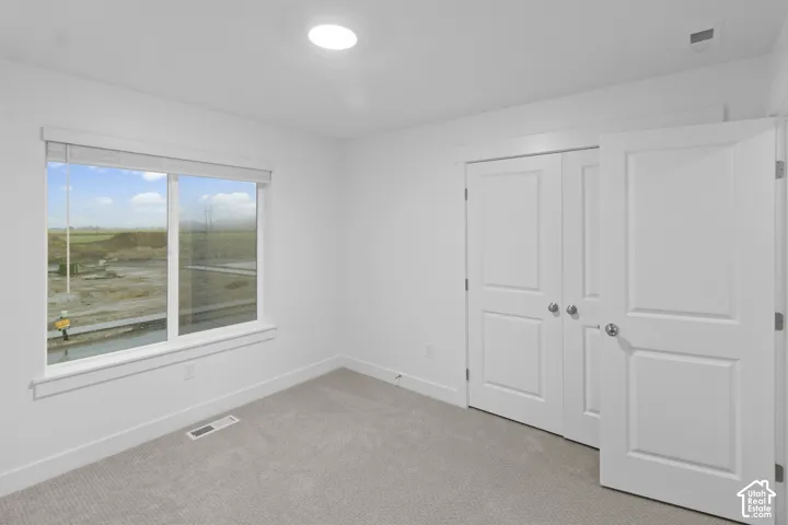 Recessed lighting, light-colored carpeting, white trim, and a window with blinds