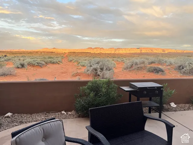 Outdoor patio with a low wall, concrete flooring, and desert landscaping