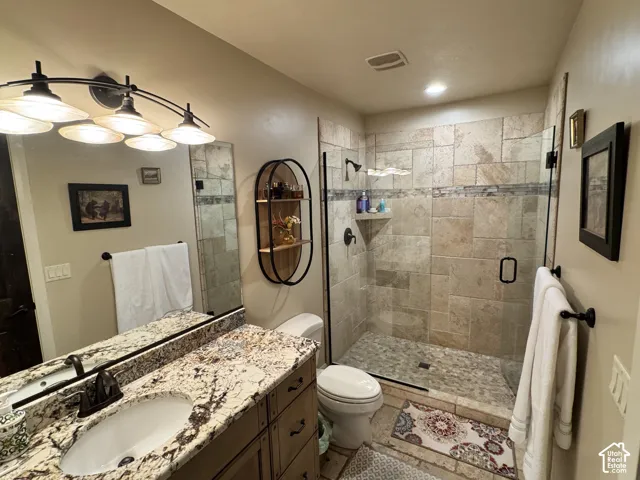 Walk-in shower with natural stone tile and glass enclosure