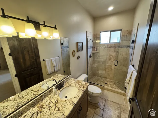 Dual-sink vanity with a patterned countertop, a large mirror, and an overhead multi-bulb light fixture