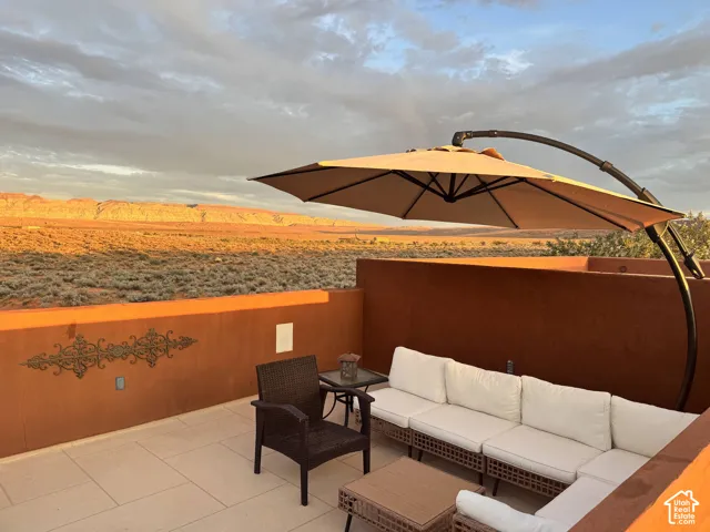 Expansive patio featuring a low-maintenance tiled surface and a built-in privacy wall with decorative metalwork