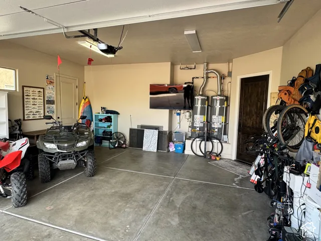 Concrete flooring with expansion joints, dual water heaters, and an overhead garage door opener mechanism