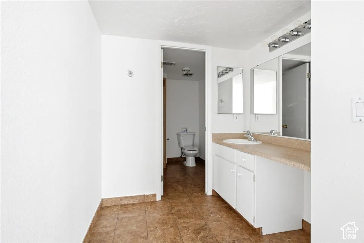Vanity with integrated sink, dual mirrors, and overhead bar lighting