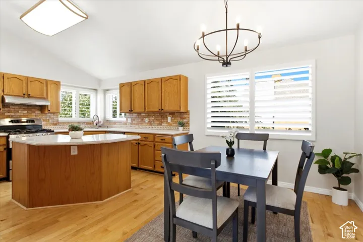 Kitchen featuring light wood cabinetry, a center island with a light-toned countertop, and stainless steel appliances