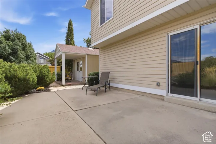 Expansive concrete patio with sliding glass door access to the interior