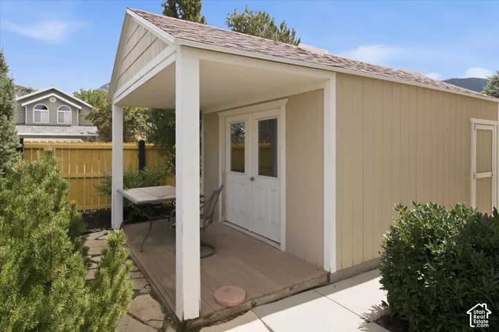 Detached outbuilding with a covered porch, wood-finish decking, and double-entry doors