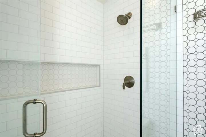 Glass-enclosed shower with subway tile walls, a built-in niche, and brushed nickel fixtures
