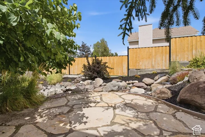 Flagstone patio with a landscaped rock garden and mature plantings
