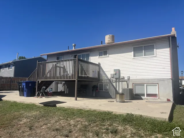 Rear exterior with white siding and a brown-stained wood deck