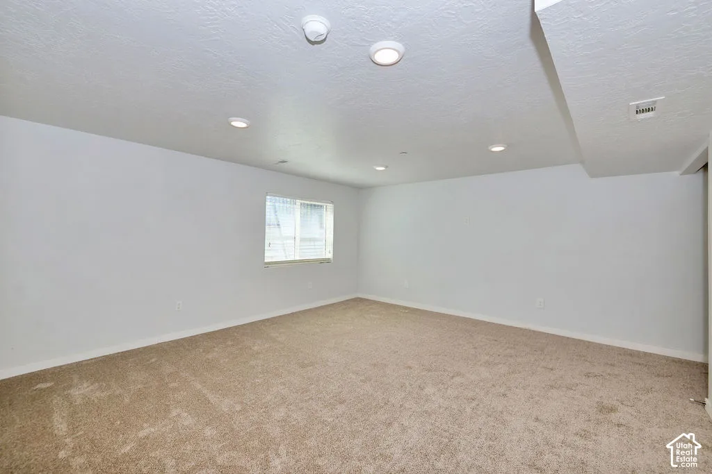 Neutral interior space featuring carpeted flooring, recessed ceiling lighting, and a single window