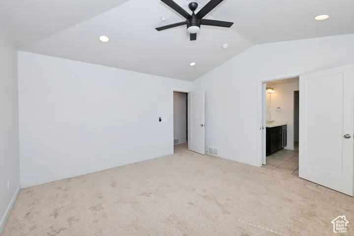 Vaulted ceiling with recessed lighting and a ceiling fan