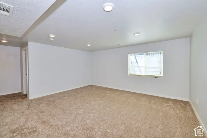 Recessed lighting, carpeted flooring, white walls, and a window with horizontal blinds