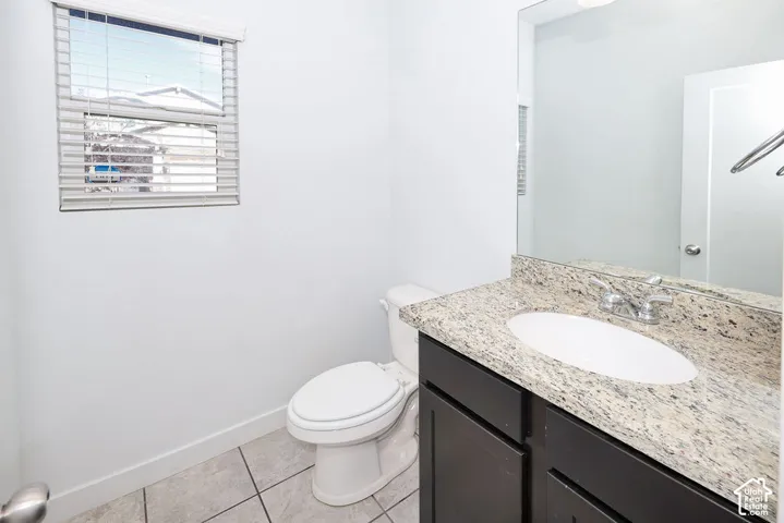 Granite-style countertop with an undermount sink, dark wood-finish vanity, and chrome-finish fixtures
