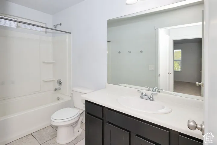 White bathtub and shower combination with chrome fixtures, a white vanity countertop, and dark wood-finish cabinetry