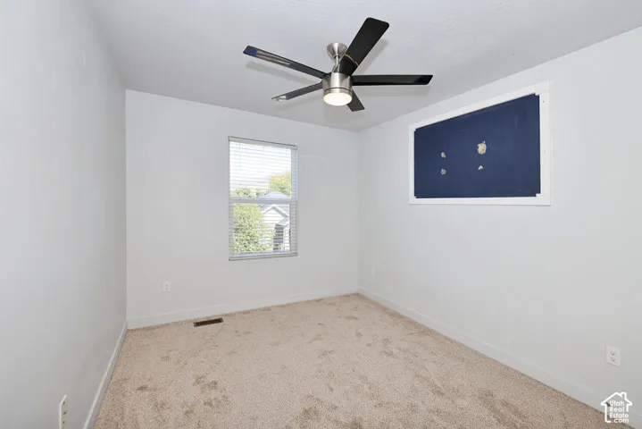Neutral wall finishes, textured carpeting, and a ceiling fan with integrated lighting