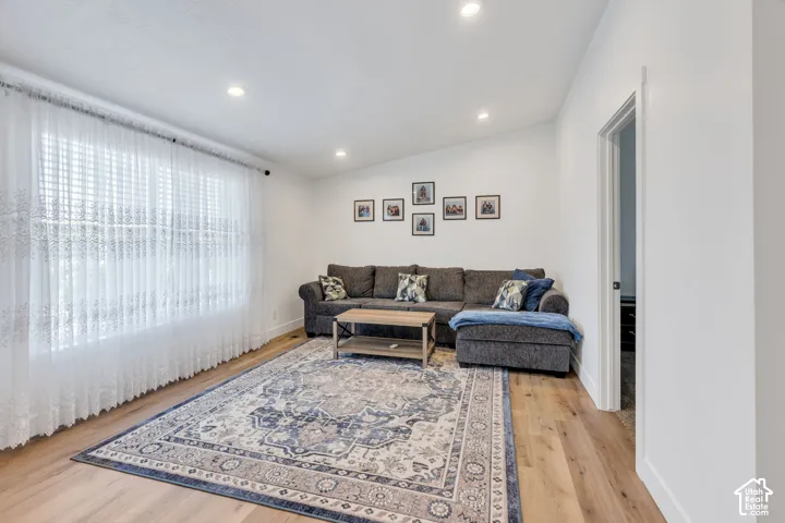Recessed lighting, wood-finish flooring, and white walls