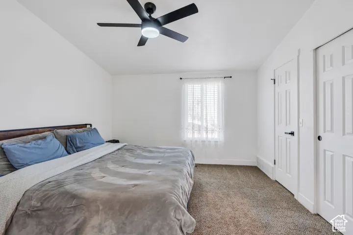 Recessed window with blinds, ceiling fan with integrated lighting, and carpeted flooring