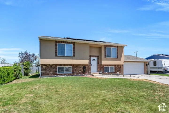 Two-story residence featuring a stucco and stone veneer exterior, an attached two-car garage, and a concrete driveway