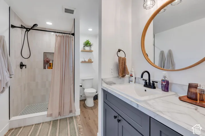 Bathroom featuring a vanity with a white countertop, dark gray cabinetry, and a round mirror
