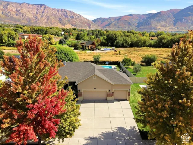 Single-story residence with an attached three-car garage, concrete driveway, and a fenced backyard with a swimming pool