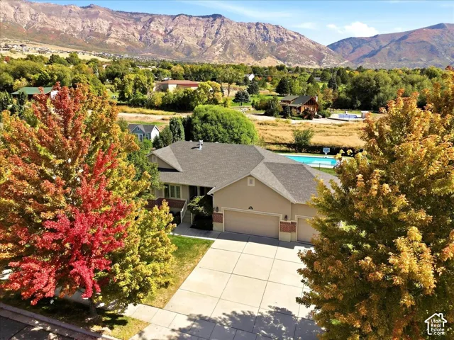 Residence featuring multiple gables, an attached garage, and a built-in swimming pool
