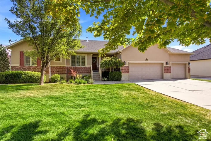 Exterior featuring a two-car garage, brick accents, stucco siding, and a concrete driveway