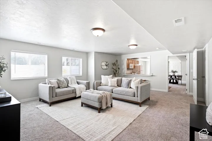 Recessed lighting, warm neutral wall tones, two windows with blinds, built-in breakfast bar, and wood-finish cabinetry