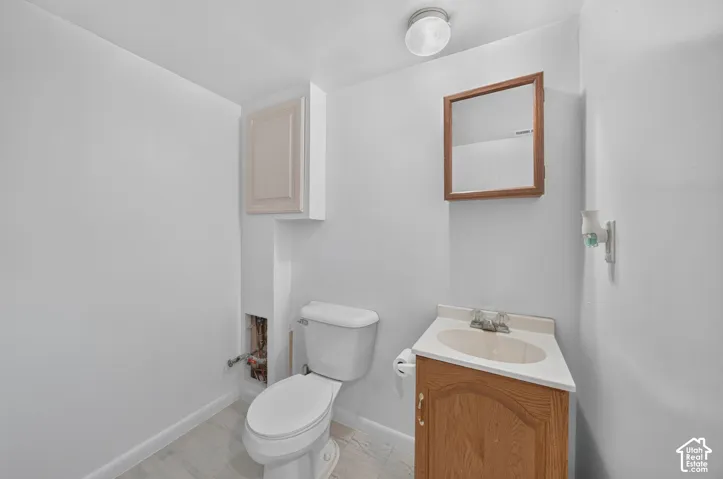 Vanity with an integrated sink, wood-finish base cabinet, and a framed mirror