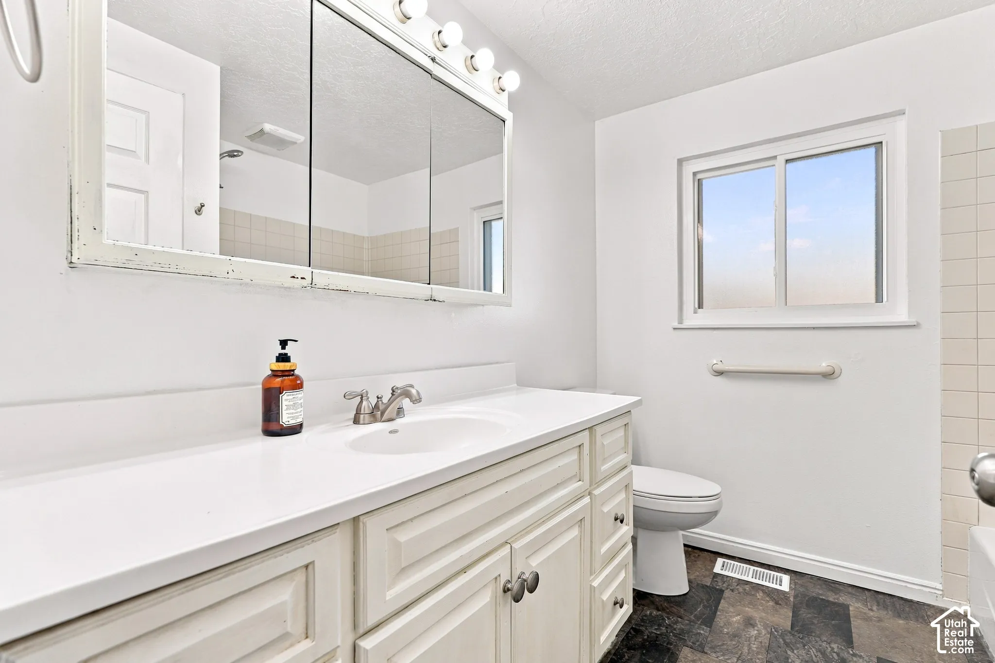 White vanity with panel detailing, integrated sink, and brushed nickel faucet