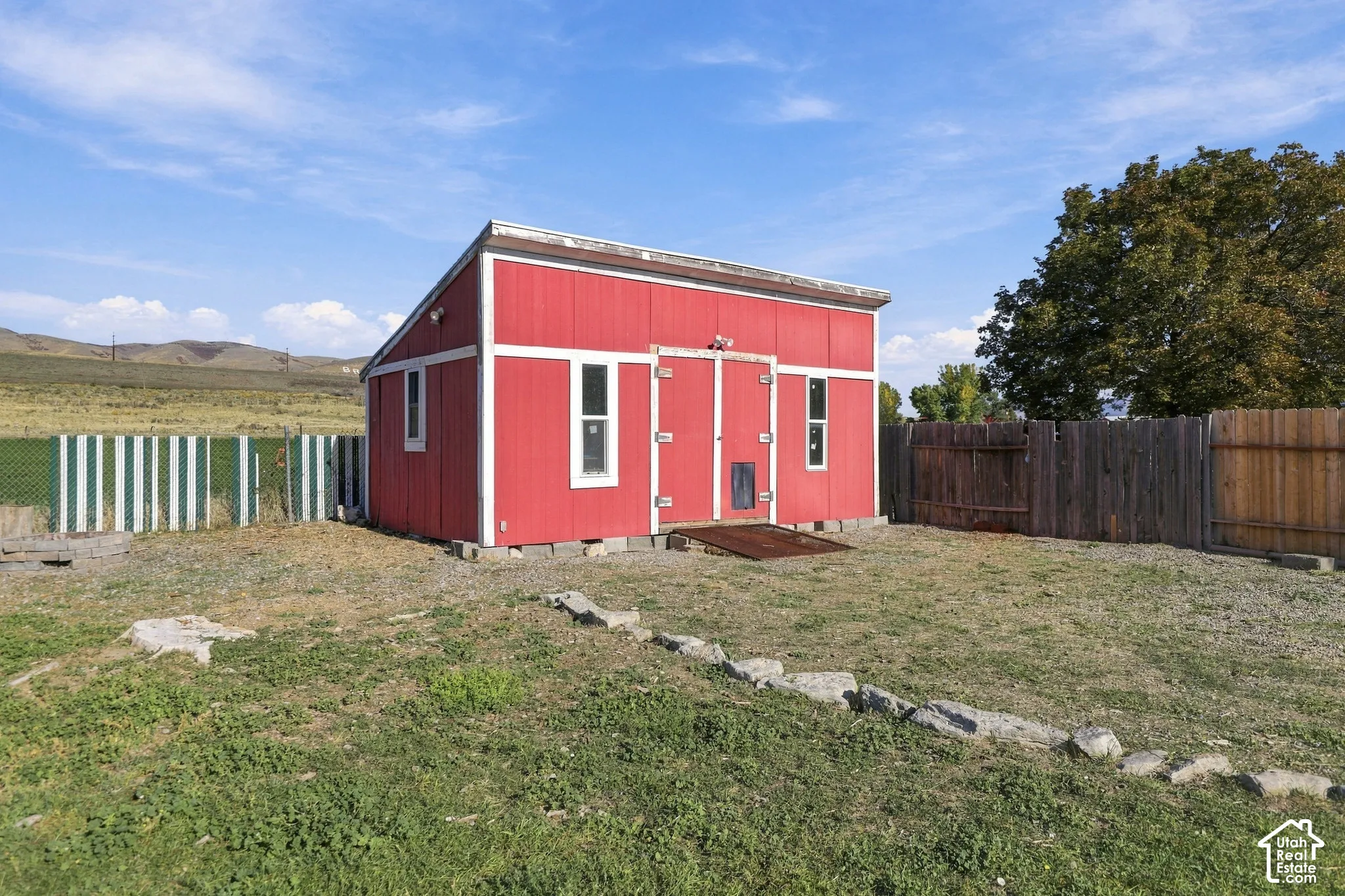 Red storage shed with white trim and multiple windows