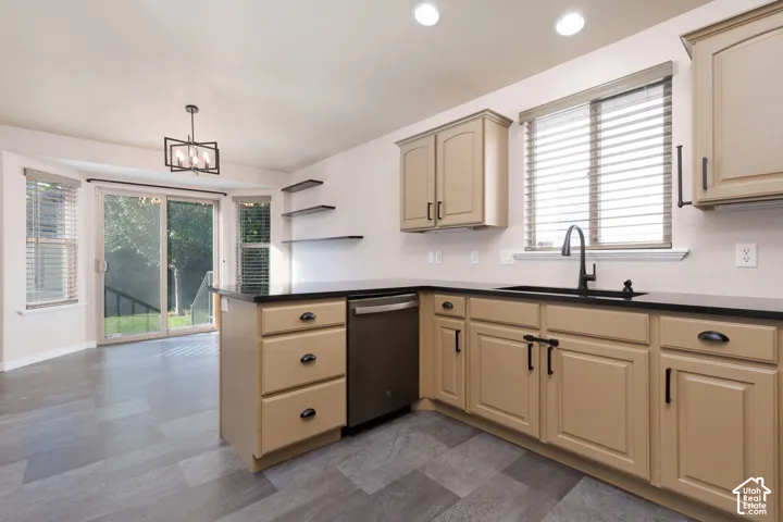 Light-toned cabinetry with dark hardware, black countertops, and a stainless steel dishwasher