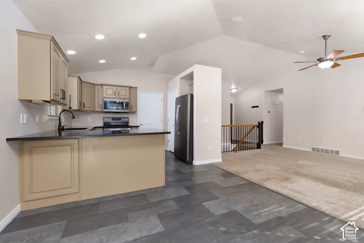 Kitchen featuring light-toned cabinetry, dark countertops, and tile flooring