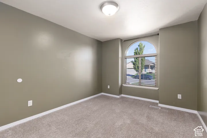 Arched window with blinds, recessed ceiling light, and neutral-toned wall paint