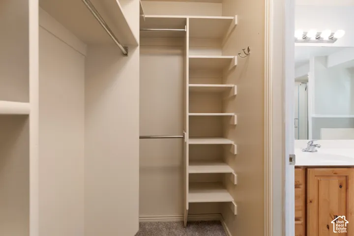 Custom closet system with multiple shelving units and hanging rods