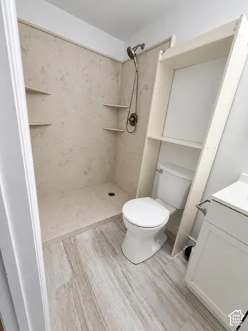 Walk-in shower with integrated shelving and a bronze-finish showerhead