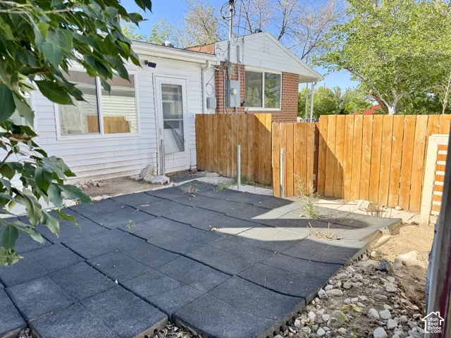 Backyard patio featuring modular rubber flooring and a wood privacy fence