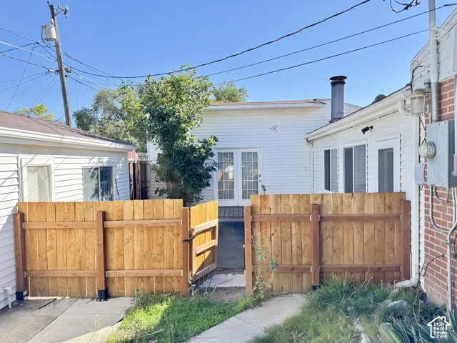 Wood fence with gate, white siding, and brick exterior