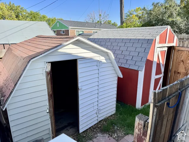 Two storage sheds with asphalt shingle roofs and hinged doors