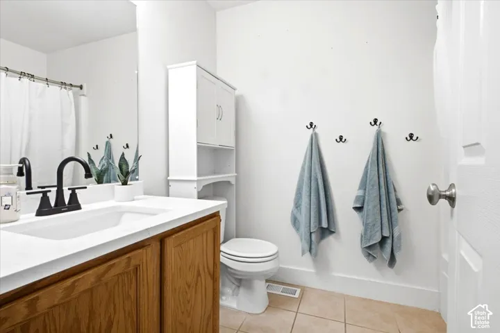 White vanity with a rectangular integrated sink, matte black faucet, and wood-finish cabinetry