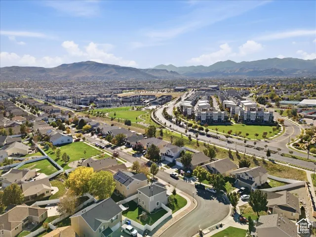Residential neighborhood with varied architectural styles, green spaces, and mountain backdrop