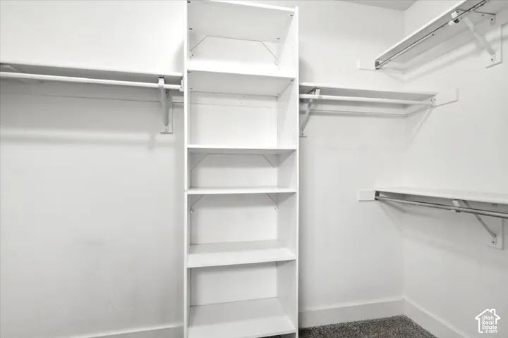Built-in shelving unit, multiple clothing rods, and overhead shelving provide ample storage