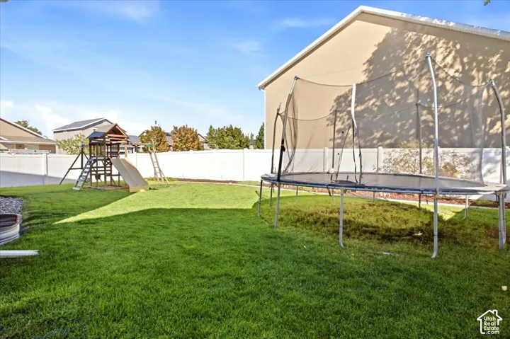 Expansive green lawn with a white privacy fence