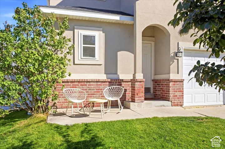 Stucco exterior with brick detailing, arched entryway, and attached garage